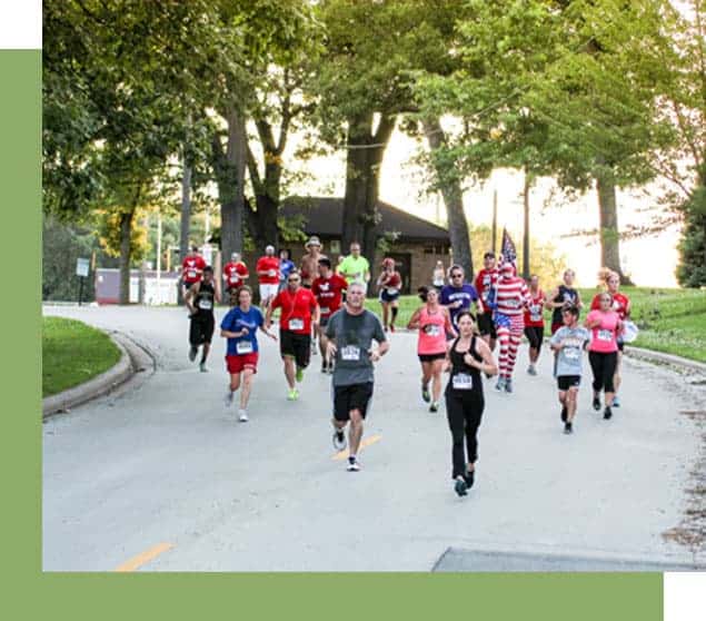 runners running down the street with trees