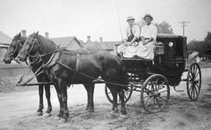 black and white horse buggy with people riding