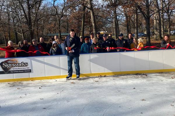 Group ribbon-cutting ceremony at outdoor ice rink.