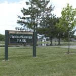 Park sign "Fields of Saratoga" in Morris, with trees.