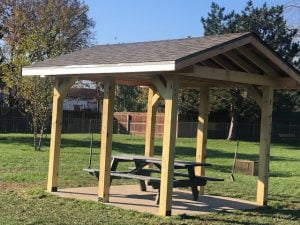 Wooden park shelter with picnic table.