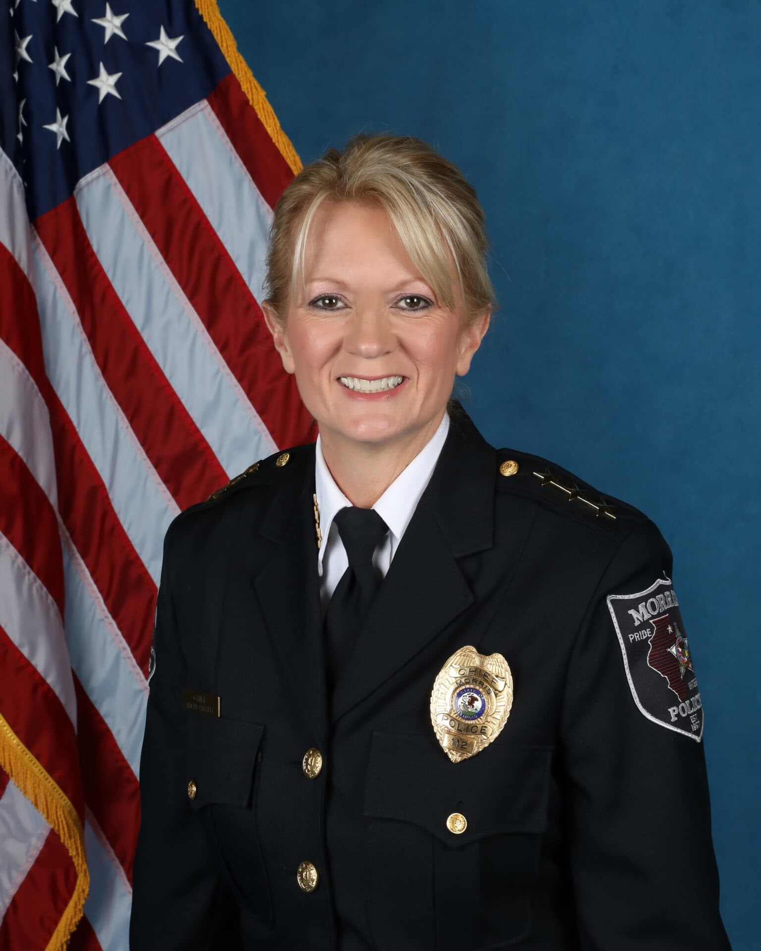 Female police chief in uniform before American flag