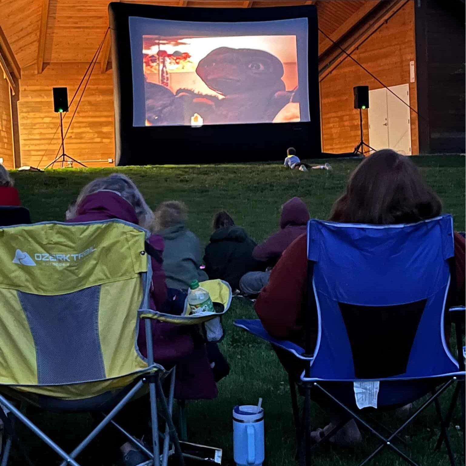 Outdoor movie night with audience and inflatable screen.